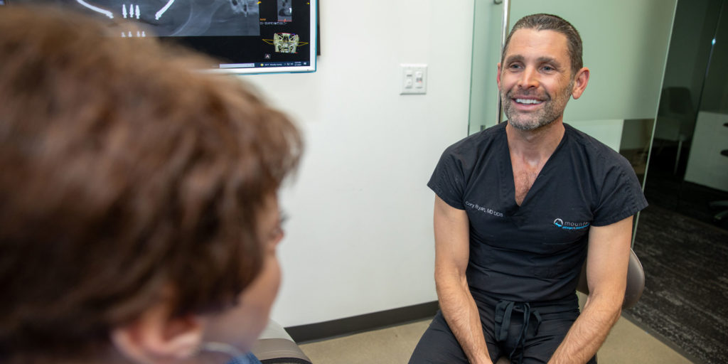 cory ryan consulting with dental implant patient after procedure